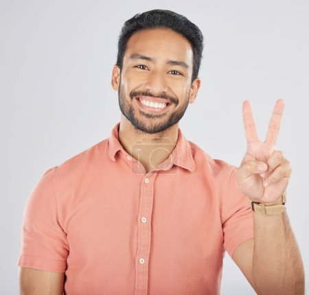 Photo for Portrait, smile and asian man with peace hands in studio for thank you, support or feedback on grey background. V, emoji and face of happy Japanese guy model with feedback, opinion or positive review. - Royalty Free Image
