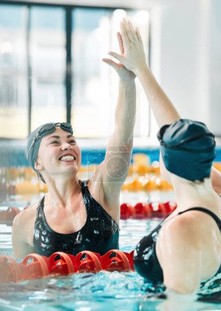 Photo for Fitness, swimmer and women with high five, smile and achievement with workout, competition and winning. People, winner and champion in a pool, celebration or support with success, sports and wellness. - Royalty Free Image