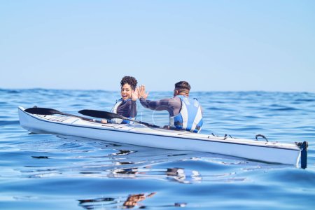 Photo for Water, man and woman in kayak with high five on lake, beach or river in sports challenge on vacation. Ocean holiday, adventure and fitness, happy couple in canoe for training success and winning race. - Royalty Free Image