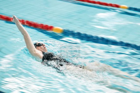 Photo for Sports, swimming pool and woman swimmer training for a race, competition or tournament. Fitness, workout and female athlete practicing back stroke cardio water skill for exercise, speed or endurance - Royalty Free Image
