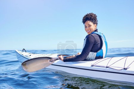Photo for Water, sports and portrait woman in kayak at lake, beach or river for exercise, race or challenge. Ocean holiday, adventure and fitness, happy girl in canoe for training workout or fun competition - Royalty Free Image