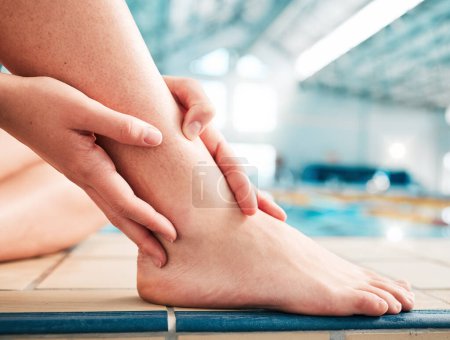 Photo for Sports injury, ankle pain and closeup with person at swimming pool for fitness, training or health. First aid, emergency and accident with woman and problem for muscle ache, inflammation and medical. - Royalty Free Image