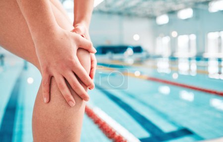 Téléchargez les photos : Personne, mains et nage dans une blessure au genou, douleur ou douleur causée par un accident sportif ou une urgence près d'une piscine intérieure. Gros plan d'un athlète sportif ou d'un nageur avec des jambes endolories, de l'arthrite ou une blessure à l'entraînement physique. - en image libre de droit