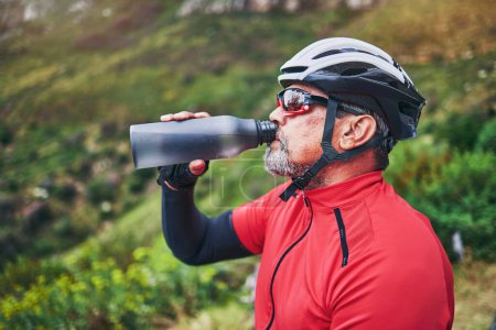 Téléchargez les photos : L'homme, le cycliste et l'eau potable sur la montagne dans la forme physique, l'alimentation ou la nutrition naturelle dans le repos ou la pause après l'exercice à vélo. Homme assoiffé avec une boisson minérale pour la durabilité dans la formation cardio. - en image libre de droit