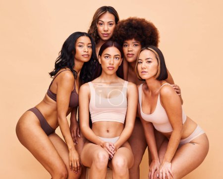 Photo for Diversity, beauty and portrait of women with body positivity, self love and solidarity in studio together. Serious face, group of people on beige background in underwear, skincare and cosmetic makeup. - Royalty Free Image