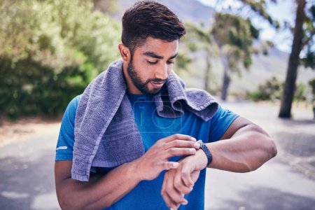 Photo for Pulse check, man and fitness watch with training results, towel and time monitoring of run outdoor. Runner, workout app, heart rate and athlete progress for sport and exercise on a road for health. - Royalty Free Image