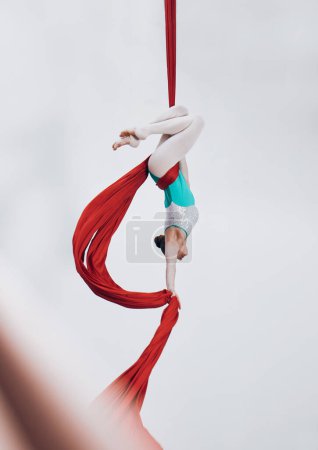 Photo for Aerial, woman gymnast and ribbon for sport performance with flexibility and athlete with white background. Workout, exercise and gymnastics with balance, art and dance with acrobat competition. - Royalty Free Image