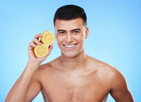 Photo for Beauty, health and portrait of man and lemon in studio for health, detox and natural cosmetics. Vitamin c, nutrition and skincare with person and fruit on blue background for self care, spa and glow. - Royalty Free Image