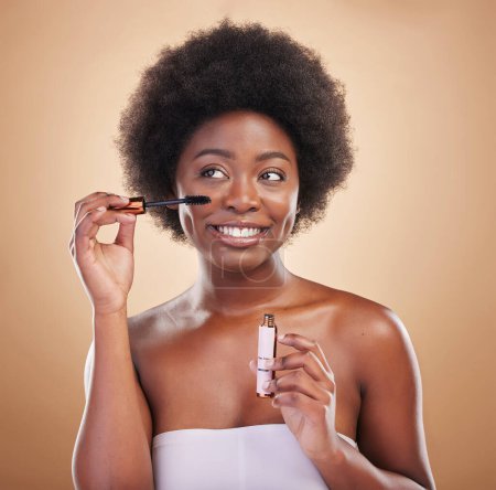 Photo for Smile, thinking and a black woman with mascara on a studio background for cosmetics and beauty. Happy, young an African girl or model with makeup idea for eyes, skincare and marketing on a backdrop. - Royalty Free Image
