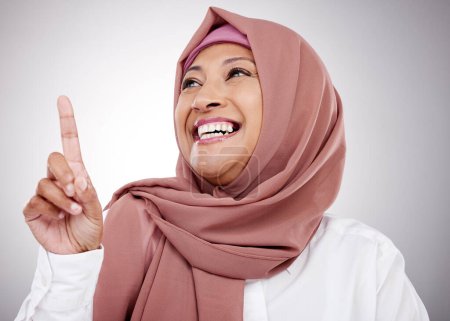 Téléchargez les photos : Musulman, pensant et une femme avec une idée en studio pour le bonheur, la gentillesse et l'attitude positive. Hijab, islam et mode islamique avec une personne mature sur fond gris pointant vers le haut à l'annonce. - en image libre de droit