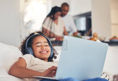 Photo for Child, laptop and headphones on sofa for happy video streaming, audio subscription and e learning at home. Kid relax on couch listening to music, games and online education on computer in living room. - Royalty Free Image