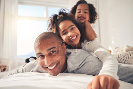 Photo for Father, portrait and happy kids on bed in home, bonding and having fun together. Face, smile and dad with children in bedroom to relax with love, care and healthy connection for family in the morning. - Royalty Free Image