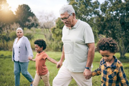 Photo for Park, grandparents and children holding hands while walking as a family together in retirement. Senior man, woman and grandkids in a nature garden for bonding on summer holiday or vacation with flare. - Royalty Free Image