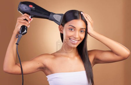 Photo for Blow dry, hair care and woman portrait with smile and happy from Brazilian treatment in studio. Salon, natural beauty and hairdresser blowing tool for hairstyle wellness with brown background. - Royalty Free Image