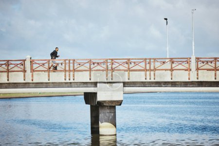 Téléchargez les photos : Exercice, ciel et un homme courent sur un pont pour un entraînement cardio ou endurance sur l'espace cloud mockup. Fitness, sport et entraînement pour un marathon avec un coureur masculin ou un athlète en plein air pour un défi. - en image libre de droit