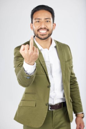 Photo for Business man, middle finger and studio portrait with anger, rude and frustrated by white background. Indian entrepreneur, smile and emoji for sign language, vote and opinion with hand for conflict. - Royalty Free Image