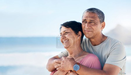 Téléchargez les photos : Couple d'âge mûr heureux et embrasser en plein air à la plage avec un sourire, soins et bonheur ensemble. Homme et femme pensant à un mariage sain, l'engagement et la liberté sur un voyage vacances avec l'espace dans le ciel. - en image libre de droit