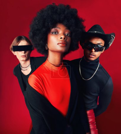 Photo for Fashion, portrait and a group of people, style and retro clothes on a red studio background for art, punk and creative aesthetic. Friends, rock or a black woman with men with vintage or trendy outfit. - Royalty Free Image