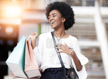 Téléchargez les photos : Femme noire, sac à provisions et client heureux marchant en plein air dans une ville pour la vente au détail, la vente ou la promotion. Africain avec un cadeau, sourire et excité à l'idée d'acheter des produits de mode sur les voyages urbains. - en image libre de droit