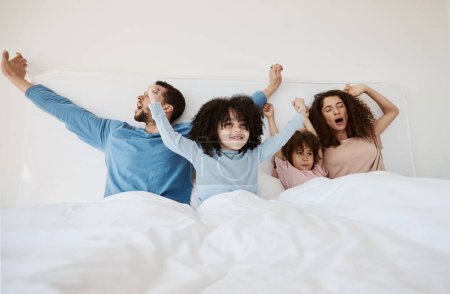 Photo for Family, bed and yawn in morning wake up, relax or sleep together with arms up at home. Calm parents, children and bonding on holiday break, weekend or new day in peace, support or comfort in bedroom. - Royalty Free Image