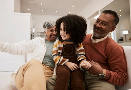 Photo for Grandparents, home smile and family kid, grandma and grandfather laughing, having fun and enjoy quality time together. Living room couch, grandfather and grandmother play with child during retirement. - Royalty Free Image