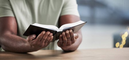 Photo for Bible, reading and man hands with book learning for religion study at home for worship and spiritual support. Faith, christian knowledge and person with gratitude, scripture education and guidance. - Royalty Free Image