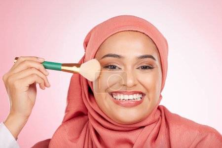 Photo for Makeup, brush and muslim woman portrait with a smile from cosmetics and blush in studio. Facial, glow and happy female person with beauty, skincare and shine with a hijab and skin tool for face. - Royalty Free Image