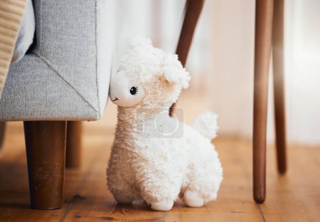 Photo for Teddy bear, empty room and toy on floor of home, background and alone by sofa in lounge of house. Abandoned, lonely and stuffed animal for grief, mental health, loss and sad or security by couch. - Royalty Free Image