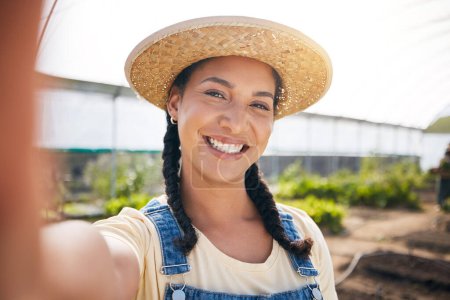 Foto de Selfie, sonrisa y una mujer en un invernadero agrícola para la agricultura o la sostenibilidad natural en la temporada de cosecha. Retrato, agricultura y una joven agricultora feliz en un jardín para un crecimiento ecológico. - Imagen libre de derechos
