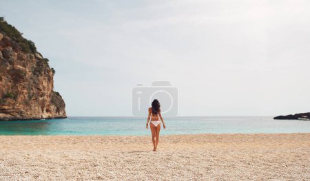 Téléchargez les photos : Belle femme en bikini sur la plage paradis jouissance de vacances de voyage en bonne santé. - en image libre de droit