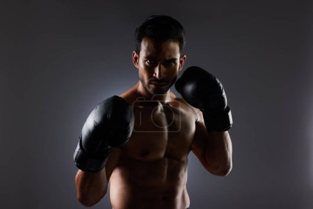 Photo for Boxing, studio portrait and sports man with fitness challenge motivation, gym club commitment and fight power workout. Dark shadow, boxer training exercise and strong MMA athlete on grey background. - Royalty Free Image