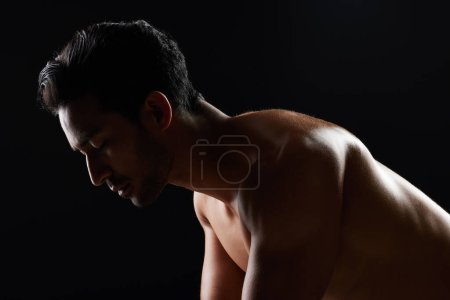 Photo for Exercise, strong and studio man doing push up challenge, gym fitness routine and workout for muscle building. Dark shadow light, body training development and calm sports athlete on black background. - Royalty Free Image