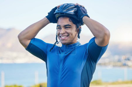 Photo for Cycling helmet, exercise and a man outdoor for sports, workout or training with a happy smile. face of a young athlete or cyclist with safety, wellness and fitness at park or thinking of performance. - Royalty Free Image