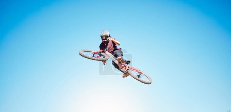 Photo for Sky, cycling and a person jump outdoor for sports, workout or training with skills and stunt. Athlete or cyclist with safety, wellness and fitness or banner space with balance and bicycle in air. - Royalty Free Image