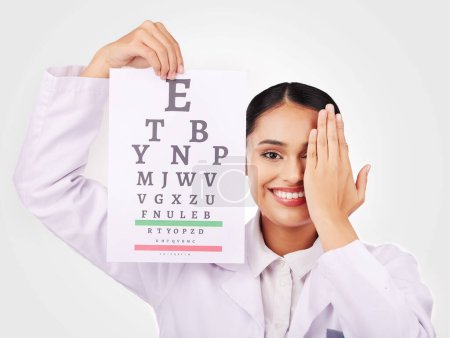 Photo for Portrait, smile and eye test with a woman optician in studio on a gray background for vision or eyesight. Face, medical and a happy young doctor in a clinic or optometry office for a visual exam. - Royalty Free Image