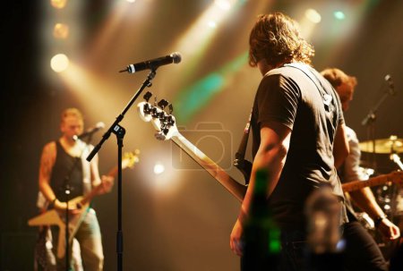Photo for Performance, musician and men in a band at a concert for a music festival, event or show together. Night, stage and a group of people performing, singing and playing instruments at a club for a party. - Royalty Free Image