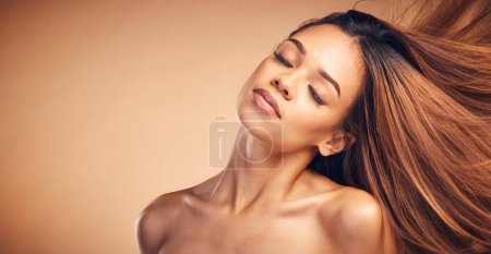 Photo for Mockup, beauty and hair with a natural woman in studio on a brown background for keratin treatment. Face, space and shampoo with a confident young model at the salon for growth or aesthetic haircare. - Royalty Free Image