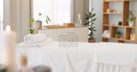 Téléchargez les photos : Bien-être, détente et table de massage sur fond de spa vide pour un bien-être ou un traitement de luxe. Santé, zen et hospitalité avec des bougies pour la paix ou l'aromathérapie une chambre d'un salon de beauté moderne. - en image libre de droit
