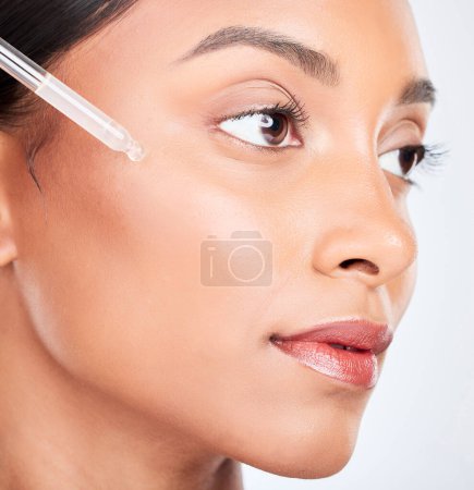 Photo for Face, woman and pipette with skincare, serum and dermatology with wellness on white studio background. Person, cosmetic product or model with hyaluronic acid, aesthetic or shine with oil and beauty. - Royalty Free Image
