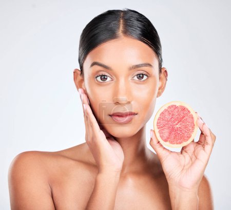Photo for Face, woman with grapefruit and natural beauty, facial and eco friendly skincare portrait on white background. Wellness, fruit and vegan cosmetic product with glow, vitamin c and citrus in studio. - Royalty Free Image