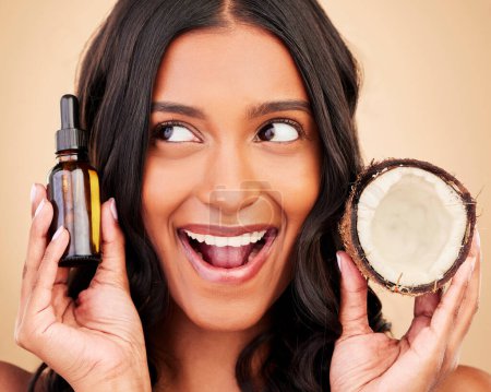 Photo for Happy woman, hair and beauty, coconut oil product with natural treatment and cosmetic care on studio background. Haircare, eco friendly and vegan with fruit, serum and shampoo with bottle and shine. - Royalty Free Image