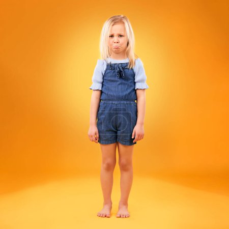 Photo for Portrait, sad and girl child in studio with bad news, feedback or negative review on orange background. Face, frown and kid with emoji disappointed expression, angry or tantrum, reaction or behavior. - Royalty Free Image