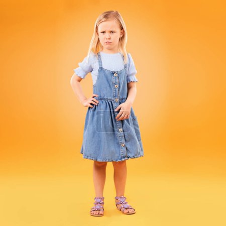 Photo for Angry, sad and portrait of girl child in studio with bad news, feedback or negative, review or vote on orange background. Face, frown and annoyed kid with emoji tantrum, behavior or attitude problem. - Royalty Free Image