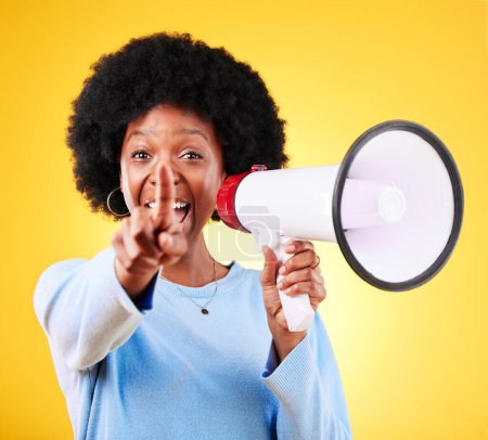 Photo for Pointing, happy woman and loudspeaker or megaphone in studio for voice or announcement. African person portrait with speaker for broadcast message, breaking news or speech on yellow background. - Royalty Free Image