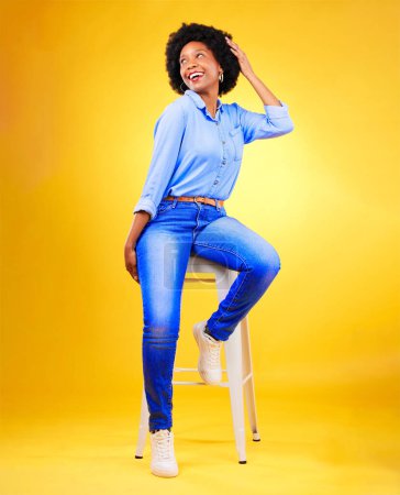 Foto de Mujer negra, pensando y sonriendo en una silla en estudio, fondo amarillo o felicidad natural con moda y estilo casual. Africano, gen z o modelo relajarse con ideas para la creatividad, maqueta o espacio. - Imagen libre de derechos