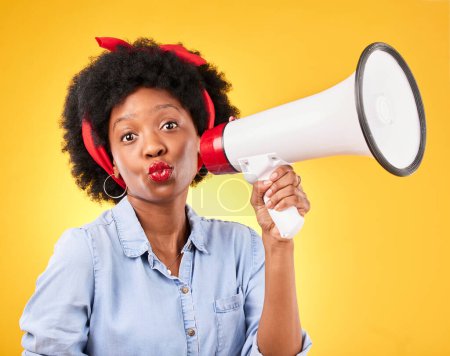 Photo for Woman, megaphone and portrait for announcement, broadcast or fashion news on yellow background. Young gen z or african person with kiss face emoji and sale, voice or discount communication in studio. - Royalty Free Image