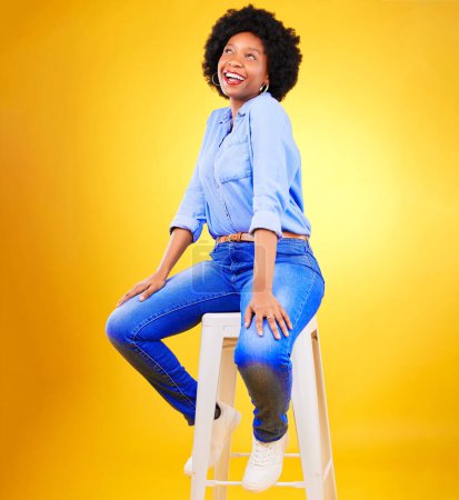 Téléchargez les photos : Femme noire, sourire et penser sur une chaise en studio, fond jaune ou bonheur naturel avec la mode et le style décontractés. African, gen z ou model relax avec des idées pour la création, la maquette ou l'espace. - en image libre de droit