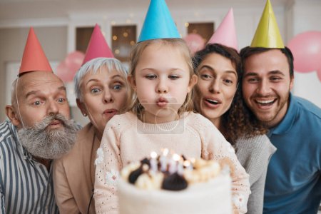 Photo for Birthday cake, candles and big family celebrate in a home party, event and happiness on face in a house together. Mother, father and grandparents excited for surprise gathering with children or kids. - Royalty Free Image