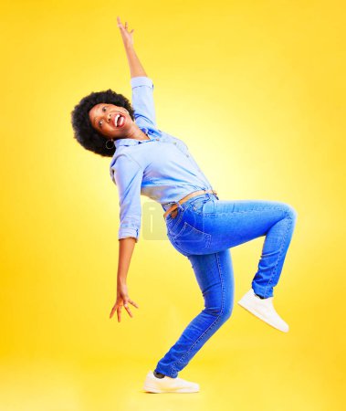Téléchargez les photos : Excité, fou et une femme en studio avec une énergie amusante, attitude positive et l'équilibre. Heureux modèle africain personne isolée sur fond jaune pour la danse de la liberté, gagnant ou wow célébration du succès. - en image libre de droit