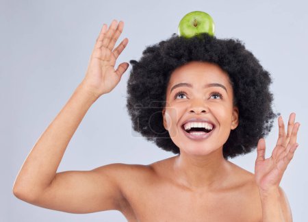 Photo for Apple balance, black woman and health with diet and natural skincare glow in studio. Happy, excited and fruit for healthy nutrition, grey background and wellness with a smile from organic food. - Royalty Free Image